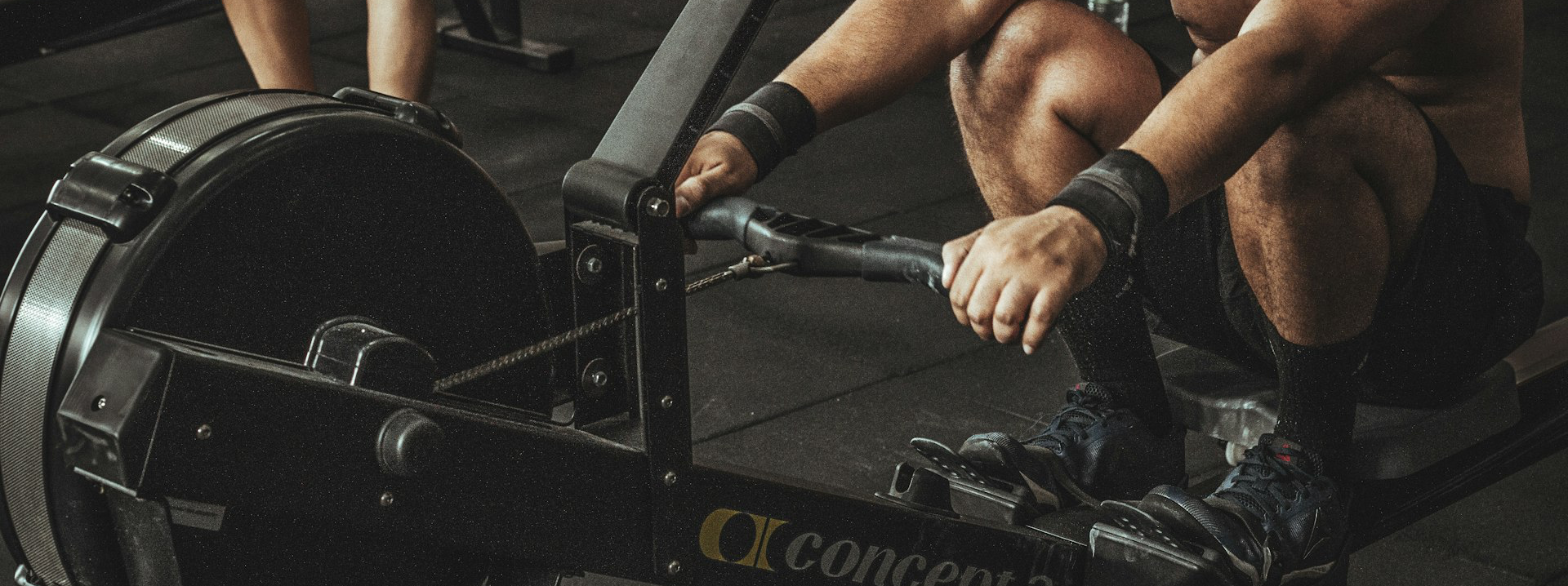 topless man using rowing machine